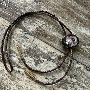 Western-style bolo tie featuring a detailed portrait of a bighorn ram